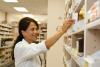 Pharmacist stocking shelf